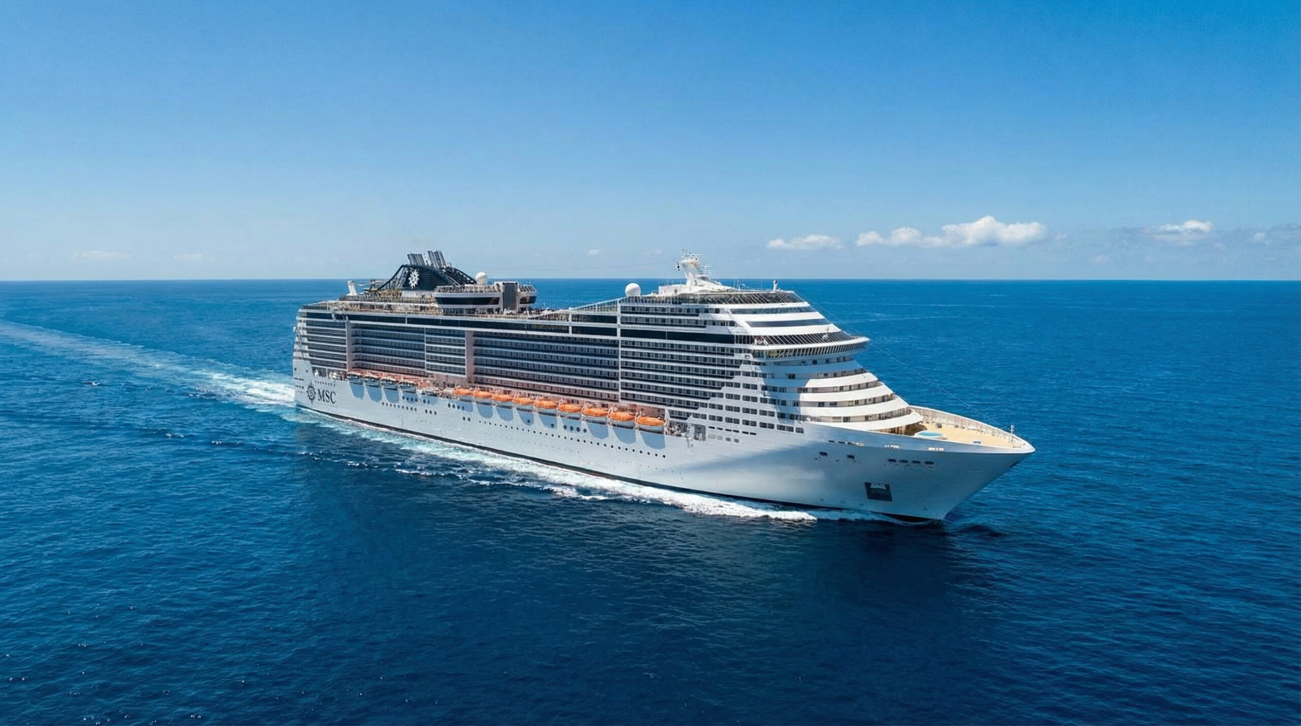 Large white cruise ship with orange lifeboat covers sailing on open blue ocean under clear sky