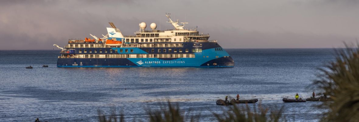 A distinctive expedition cruise ship operated by Albatros Expeditions anchors in shallow coastal