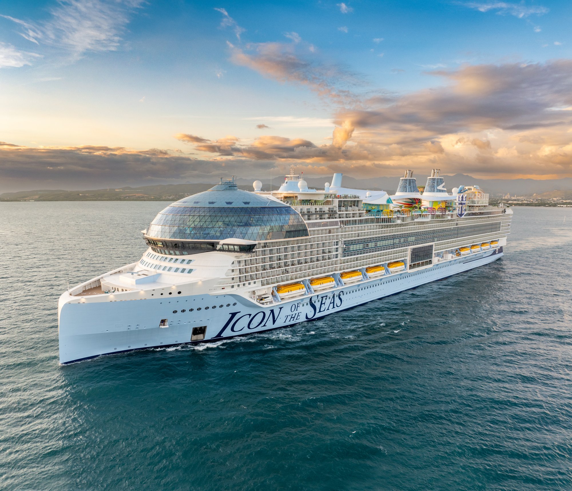 A modern mega-ship with distinctive white hull and advanced architecture sails through turquoise