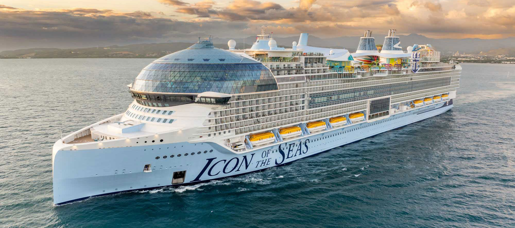 Icon of the Seas cruise ship with distinctive dome structure on water at sunset